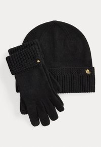 Beanie nera a maglia con design a coste, abbinata a guanti neri con polsini a coste e un piccolo logo dorato su ciascun articolo.
