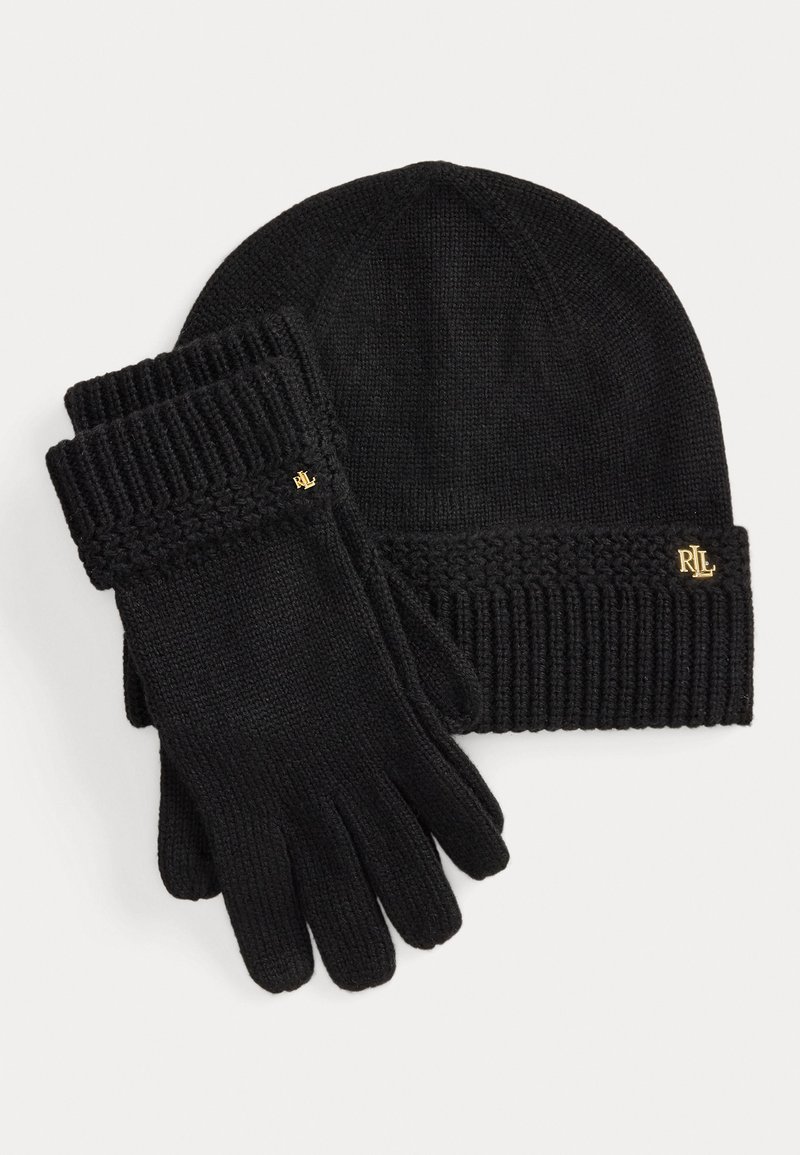 Beanie nera a maglia con design a coste, abbinata a guanti neri con polsini a coste e un piccolo logo dorato su ciascun articolo.