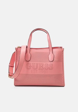 Sac cabas en cuir rose avec un design perforé et un logo embossé "GUESS EST. 1981", doté de deux poignées et d'une bandoulière réglable.