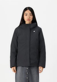 Giacca nera con cappuccio e chiusura a zip, con un logo discreto sul petto e due tasche frontali, realizzata in un tessuto liscio e resistente.