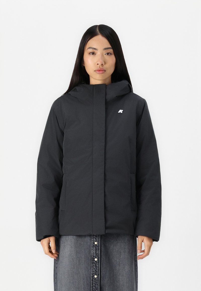 Giacca nera con cappuccio e chiusura a zip, con un logo discreto sul petto e due tasche frontali, realizzata in un tessuto liscio e resistente.