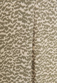 Beige stof met een abstract olijfgroen patroon, waarin verschillende texturen en vormen zijn verwerkt, wat een visueel interessante uitstraling creëert.