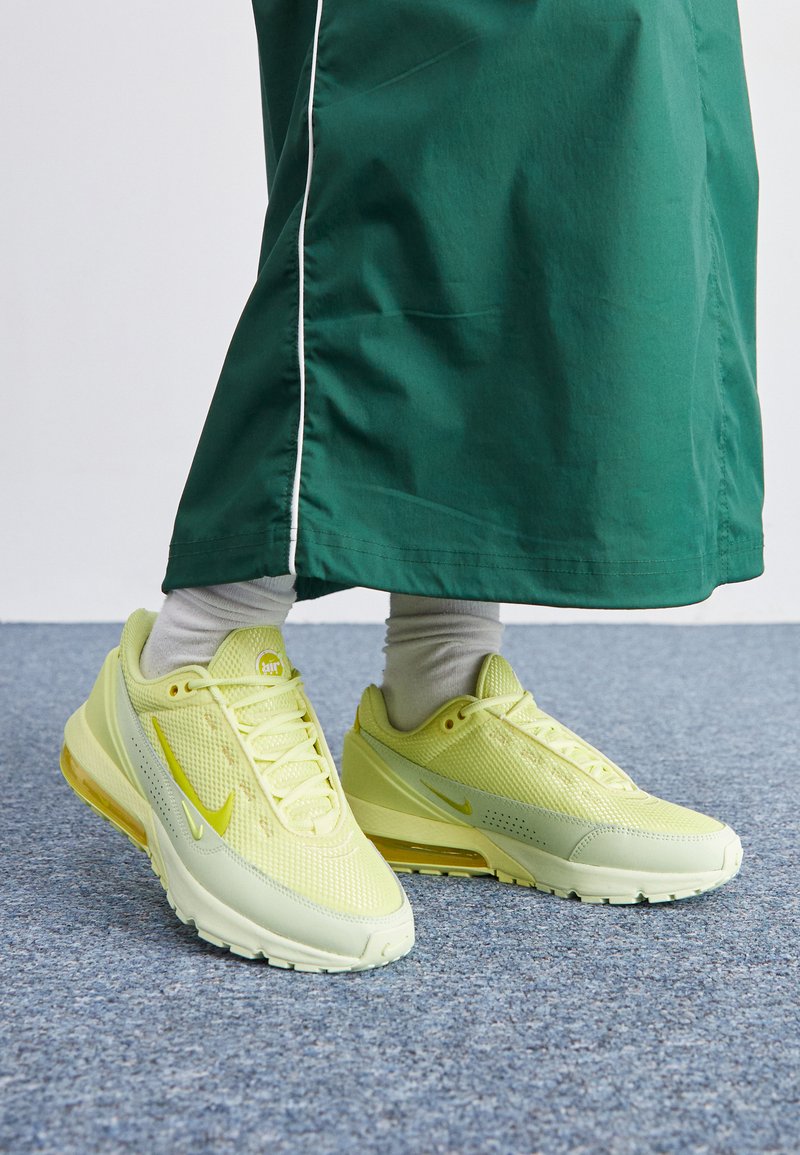 white and green nike trainers