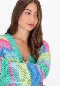 Mehrfarbiger Strickcardigan mit dicken Streifen in Grün, Blau, Pink und Lavendel. Lockere Passform mit tiefem V-Ausschnitt und strukturiertem Stoff.