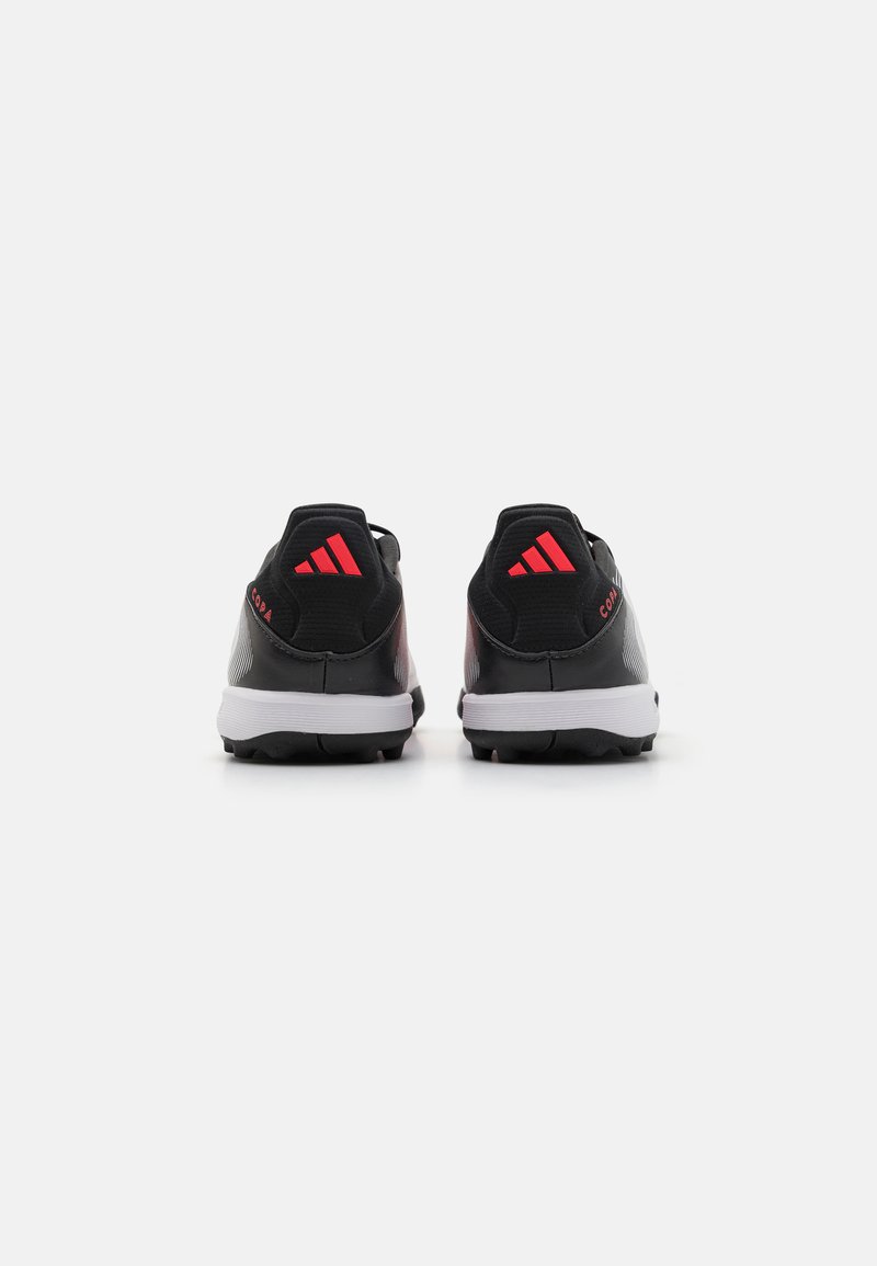 Schwarze Sportschuhe mit roten Akzenten, ausgestattet mit einem synthetischen Obermaterial, strukturiertem Design, gepolstertem Schaft und einer weißen Sohle mit Noppen für einen besseren Halt.