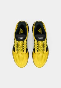 Αθλητικά παπούτσια Adidas Climacool με κίτρινο δικτυωτό πάνω μέρος και μαύρες λεπτομέρειες, αντίθετα κορδόνια και υφασμάτινη σόλα για αναπνοή.