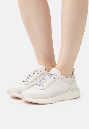 Light-colored athletic shoes featuring a mix of smooth leather and suede, with laces and a subtle patterned accent on the side.