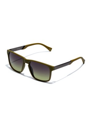 Rectangular sunglasses with olive green frame and gradient dark lenses, resting sideways on a white surface.