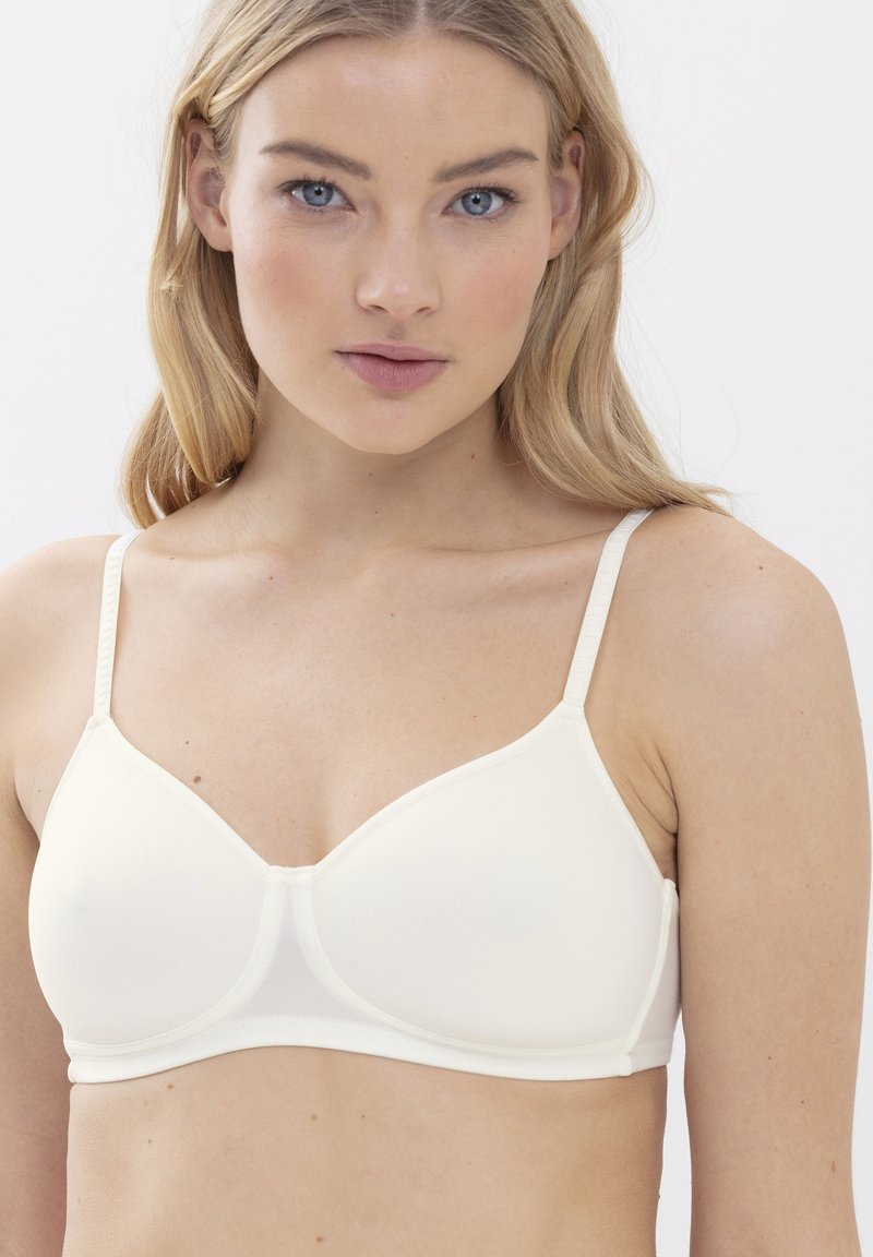 Soutien-gorge beige clair en tissu lisse, doté de bretelles réglables, d'une bande sous poitrine douce et d'un design sans coutures avec des bonnets moulés.