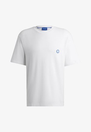 T-shirt en coton blanc avec un col rond et des manches courtes. Présente un petit logo de smiley bleu sur la poitrine. Design simple et sans ornements.