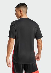 adidas Performance TIRO ESSENTIALS - Tekninen t-paita - black lucid red
