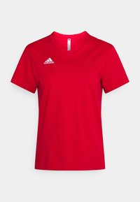 T-shirt de sport Adidas rouge à manches courtes et col en V avec logo blanc Adidas sur le côté droit de la poitrine sur un fond uni.