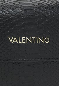 Svart faux python lær lommebok med en teksturert overflate og gull "Valentino"-logo. Enkel design med et distinkt reptilmønster.