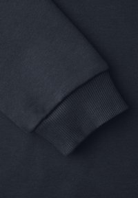 Manche de sweat-shirt bleu marine foncé avec poignet côtelé replié sur le corps en tissu assorti.