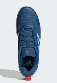 Scarpa sportiva blu con tomaia in rete, strisce laterali azzurre, logo rosso sulla linguetta e suola bianca, vista dall'alto su uno sfondo chiaro.