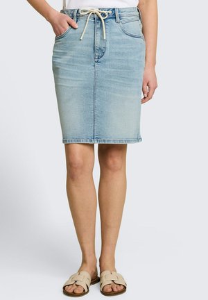 Hellblauer Jeansrock in knielanger Länge mit Vorderentaschen und weißem Kordelzug, kombiniert mit beigen flachen Sandalen und einem weißen Oberteil.