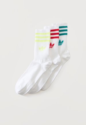 Trei perechi de șosete albe, fiecare cu dungi colorate Adidas și logo-ul trefoil în partea de sus: galben, roșu și teal.