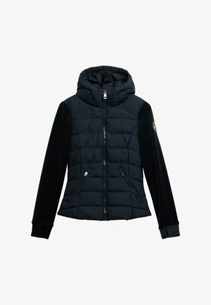 Veste noire isolée avec capuche, présentant un corps matelassé, des manches en velours lisse, des poches zippées et un logo sur la manche gauche.