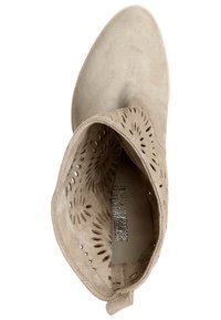 Beżowy zamszowy botek za kostkę z perforowanym wzorem, szpiczastym noskiem i przeszyciami. Gładka wewnętrzna wyściółka z teksturowaną wkładką.