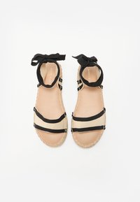 Sandale espadrile negre și bej cu curele moi din material textil, design cu vârf deschis și legături la gleznă. Talpă din iută cu detalii de cusătură contrastante.