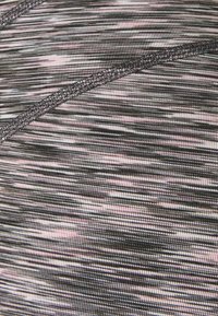 Zbliżenie na szary i różowy marmurkowy materiał z delikatnymi poziomymi liniami oraz zakrzywionym szvem przeszytym pasującą szarą nicią.