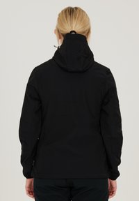 Black softshell jacket with a hood, featuring a smooth texture, structured seams, and a relaxed fit, designed for comfort and mobility.