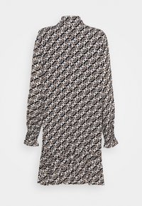 Zwarte lange mouw jurk met beige en witte abstracte kettingpatroon en gerimpelde zoom, weergegeven op een effen achtergrond.