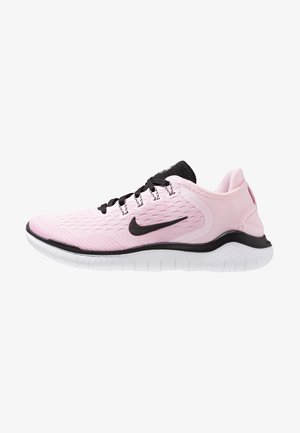Chaussure de sport rose clair avec le logo Nike noir, lacets noirs et semelle blanche flexible, vue de côté gauche sur fond blanc.