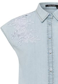 Helles blaues Denimhemd mit kurzen Ärmeln, verziert mit weißer Floralstickerei auf der linken Schulter und fünf blauen Knöpfen auf der Vorderseite.