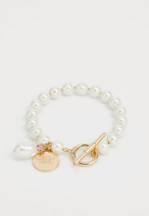 Βραχιόλι από πέρλες με λευκές στρογγυλές πέρλες, με χρυσό τόνο κούμπωμα και διακοσμητικό κρεμαστό με μονογράμματα και ροζ λεπτομέρεια.
