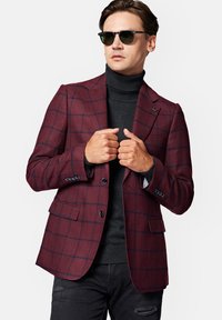 Burgundowy marynarka w kratę z teksturowanej tkaniny z granatowymi liniami. Posiada dwa guziki, klapy ze wcięciem i jest zestawiona z czarnym golfem.