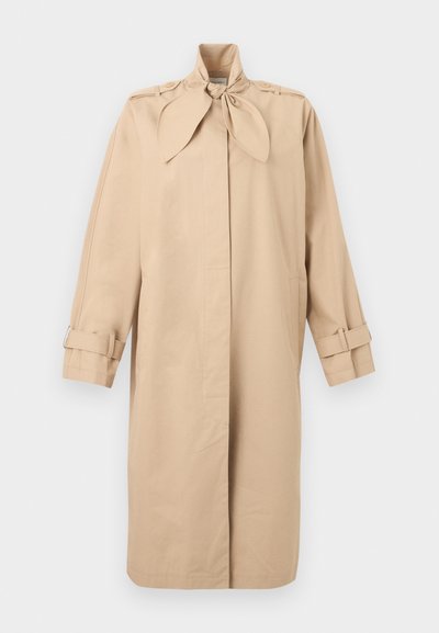 Béžový dlhý trenčkot s vysokým golierom na viazanie, zapínanými nášivkami na ramenách a nastaviteľnými popruhmi s prackami na rukávoch.