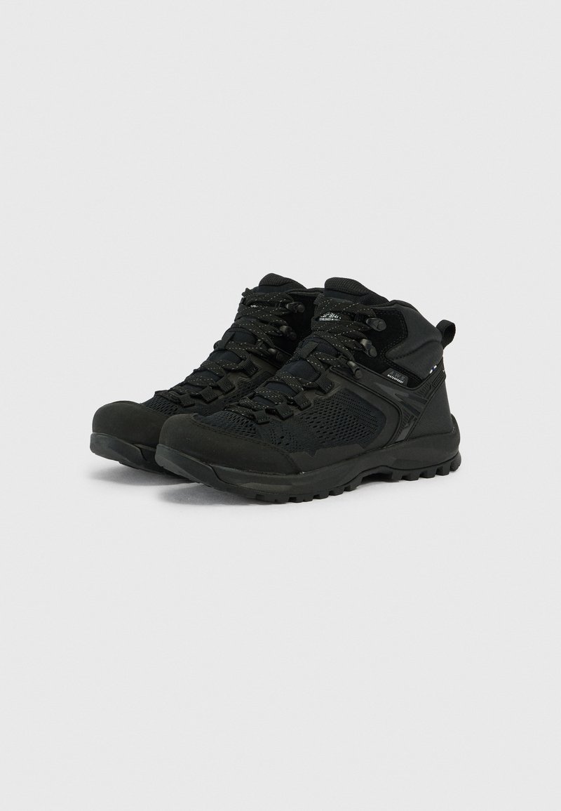 Para czarnych wodoodpornych butów turystycznych z wytrzymałymi podeszwami i sznurowanym przodem na jednolitym jasnym tle.