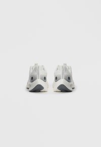 Pair of white athletic shoes with gray accents, shown from the back on a plain white background.