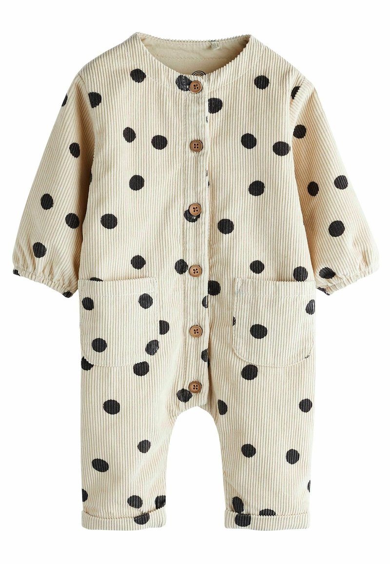 Beige corduroy overall met zwarte stippen, ronde kraag, knoopsluiting, twee voorzakken en elastische manchetten bij de mouwen en ankels.