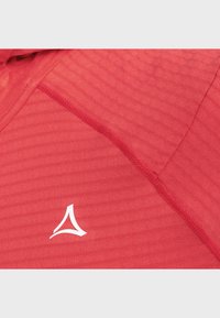 Rotes Sport-Shirt aus strukturiertem Stoff, mit kurzen Ärmeln und einem weißen Logo. Das Design zeigt gerippte Muster und verstärkte Nähte.