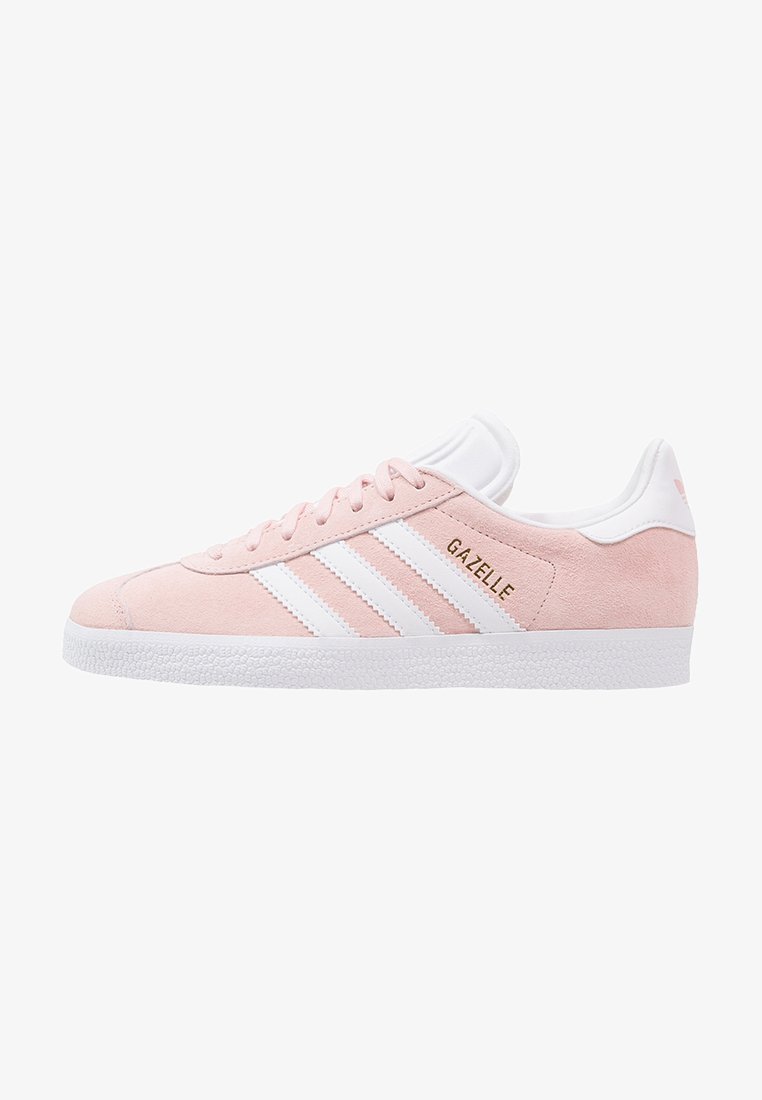 Gaiši rozā zamša sporta apavi ar trim baltām svītrām, zeltītu "Gazelle" logo un teksturētu baltu gumijas zoli. Klasisks zema profila dizains.
