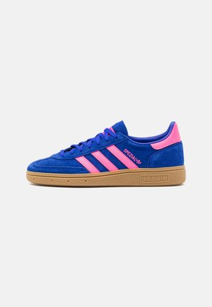Blauwe suède sneaker met roze strepen, rubberen gumzool en getextureerde accenten. Beschikt over een ronde neus en platte veters. Merkopdruk op de zijkant.