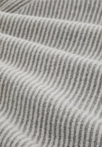 Grijs-wit gestreepte stof met een zachte textuur, met afwisselend smalle en brede strepen die een golvend patroon vormen.