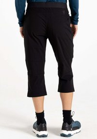 Schwarze, knielange Freizeithosen mit einem elastischen Bund, zwei Gesäßtaschen und wasserabweisendem Material. Tragen mit schwarzen Socken und Schuhen.