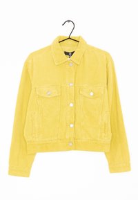 Gul kordjacka avkortad med silverböjlar, två framfickor med lock och sidofickor på en svart galge mot vit bakgrund.