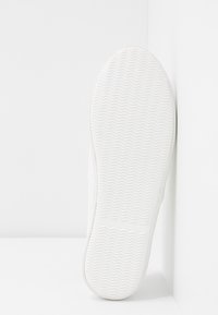 Semelle de sneaker blanche avec un motif herringbone texturé, forme plate et bords lisses. Fini mat sans marquage ni accents visibles.