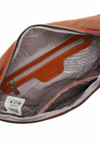 Binnenaanzicht van een oranje geweven handtas, met een beige voering, leren zakje en zilveren rits. Inclusief merkembleem en verzorgingslabel.