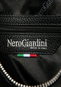 Schwarzes Lederinterieur mit strukturierter Oberfläche, geprägt mit "NeroGiardini" und "Made in Italy", sowie einem kleinen italienischen Flaggen-Etikett.