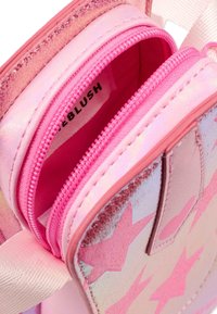 Pochette multifunzionale rosa con due scomparti con zip, materiale lucido, motivi a stella e finitura testurizzata. Etichetta interna visibile.