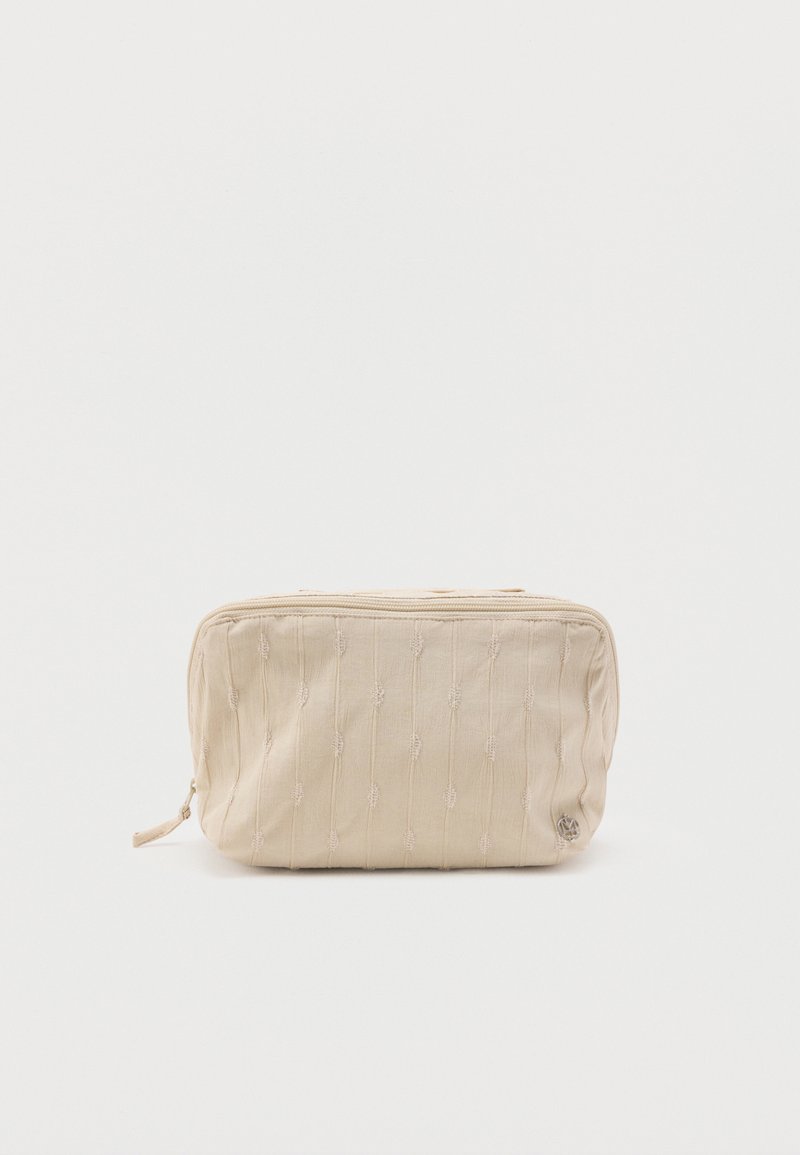 Μπεζ ορθογώνιο υφασμάτινο τσαντάκι με κάθετες υφασμάτινες γραμμές και φερμουάρ στο πάνω μέρος, σε απλό λευκό φόντο.