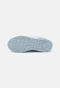 Light blue sneaker sole featuring textured grip patterns and a smooth finish, highlighting geometric shapes and detailed tread design.
