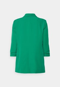 Blazer verde con un diseño estructurado, que cuenta con un cuello con muesca, mangas tres cuartos y una tela suave. Sin cierres visibles.