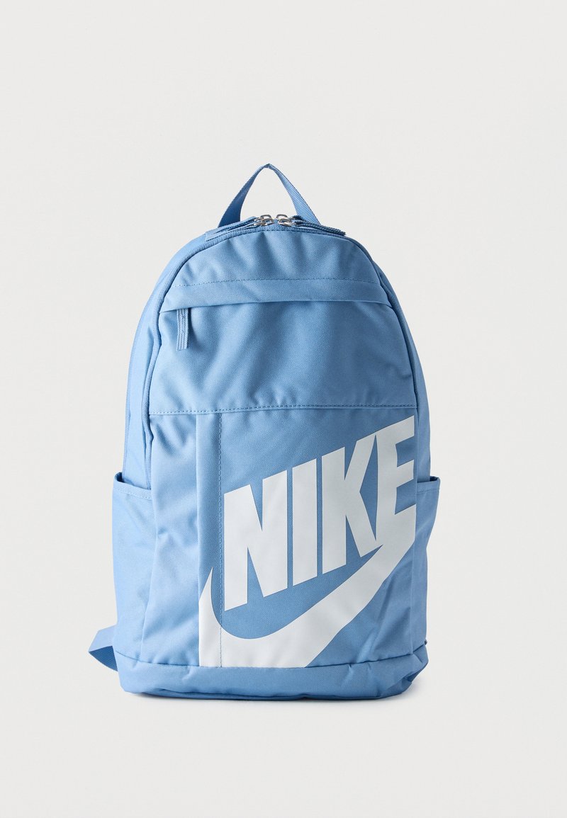 Ανοιχτό μπλε σακίδιο πλάτης με μεγάλο λευκό λογότυπο Nike στην μπροστινή τσέπη και φερμουάρ στο κύριο διαμέρισμα σε απλό φόντο.