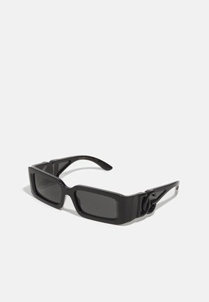 Óculos de sol pretos com formato retangular, armações grossas e lentes escuras. Apresenta um acabamento brilhante e um detalhe de hardware distintivo nas hastes.
